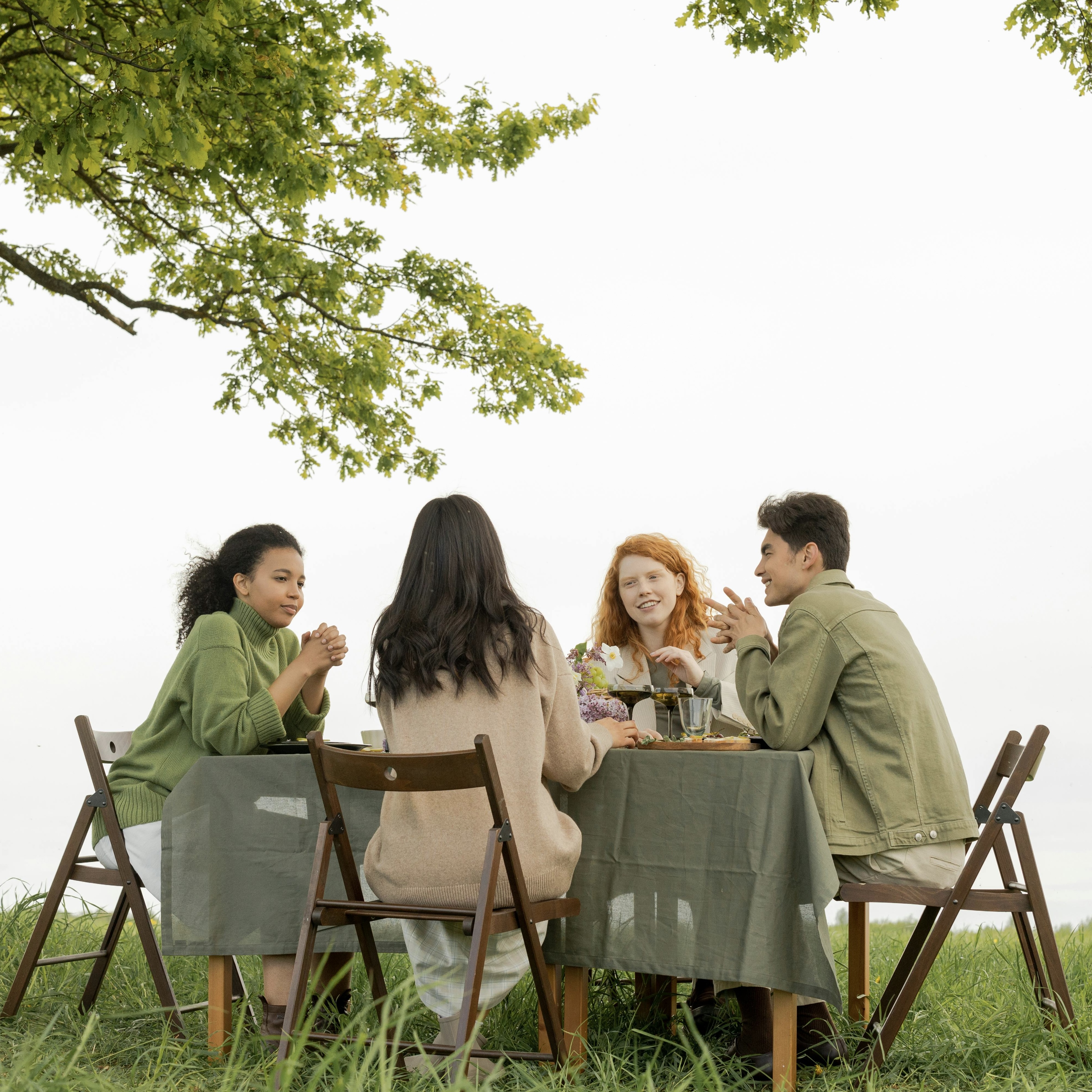 People sitting together at a table outdoors, representing community